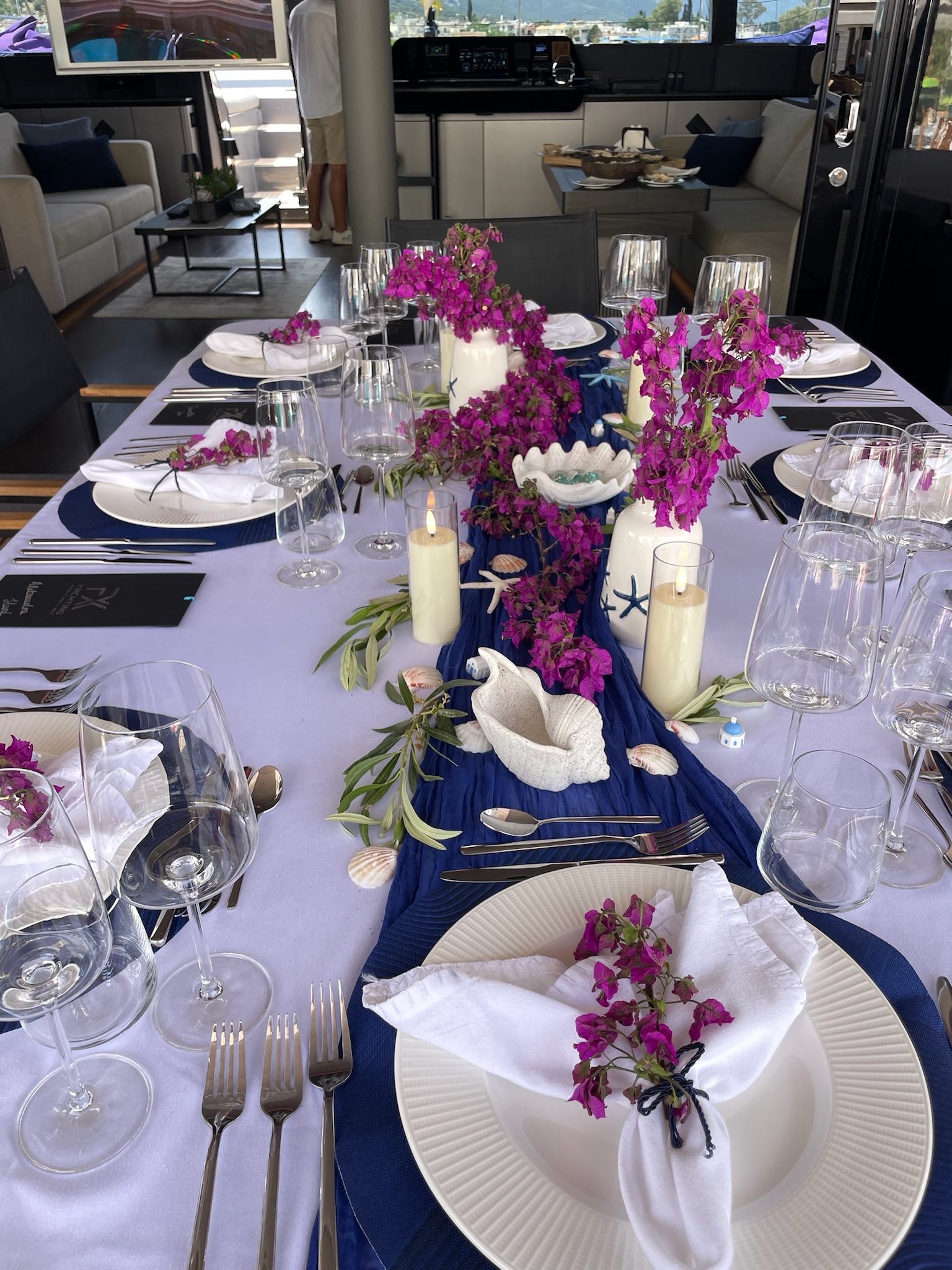 Table laid on the aft deck of ADARA NEXT with bougainvillea and candles